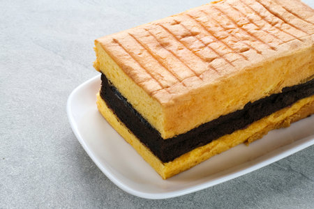 Spiku or Lapis Surabaya or Surabaya Layer Cake is a three-layer sponge cake with strawberry jam in...