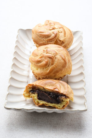 Chocolate Soes Cakes ( Sus Vla ), served in white plate, copy space.