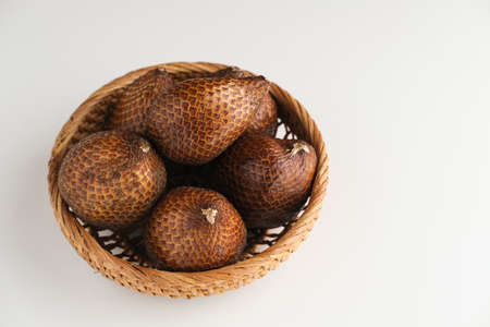Salak or thorny palm or snake fruit (Salacca zalacca) is a species of palm tree. Served in white plate on dark background. Selective focus image. Close up.の写真素材