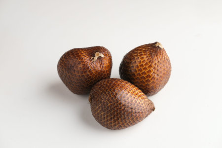 Salak or thorny palm or snake fruit (Salacca zalacca) is a species of palm tree. Served in white plate on dark background. Selective focus image. Close up.の写真素材