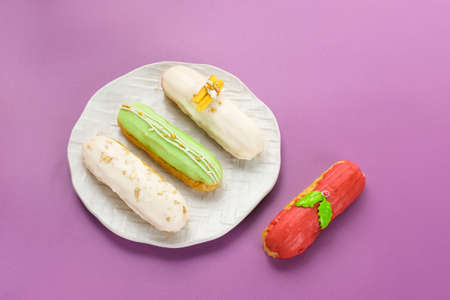 Traditional French dessert. Sweet and colorful eclairs with chocolate glaze.の写真素材