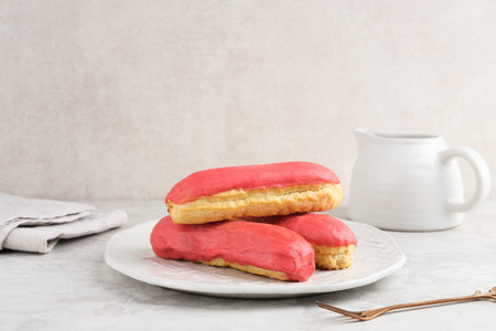 Traditional French dessert. Sweet and colorful eclairs with chocolate glaze.