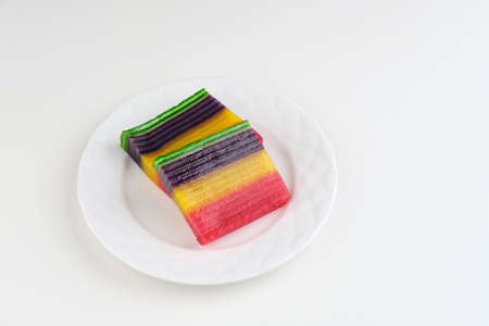 Kue Lapis or Kue Pepe or Rainbow sticky layer cake, Indonesian traditional dessert made from rice flour and coconut milk, steamed layer by layer. Served in white plate, copy space. Selective focus.の写真素材