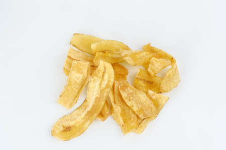 Heap of dried banana chips snack isolated on white background. Selective focus image, blurred background.の写真素材