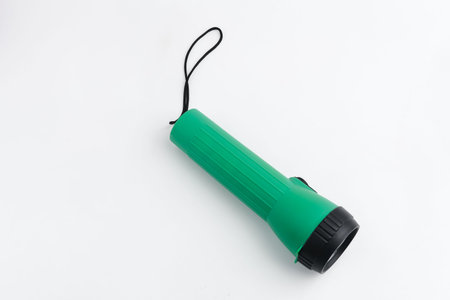 Battery-powered flashlight isolated on a white background. Copy space.
