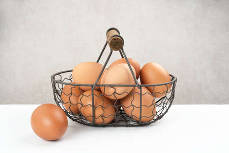 Raw organic farm eggs. Served in iron basket with copy space. Selective focus image.の写真素材