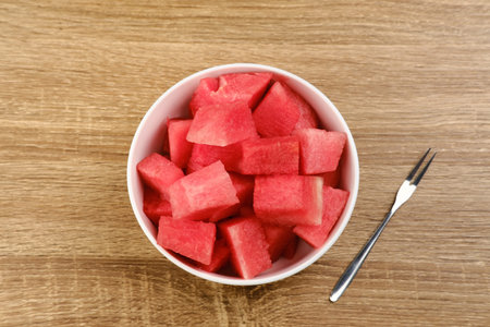 A bowl of fresh watermelon served on white bowl on wooden image. Breakfast fruit in the morning,...