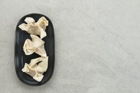 Raw Dumplings (Pangsit Mentah) served in black plate, selected focus.の写真素材