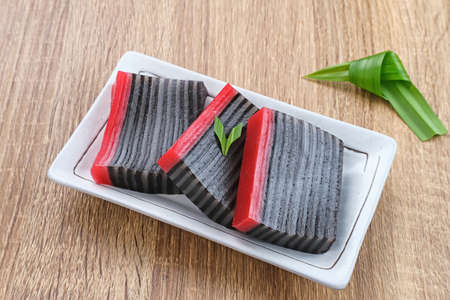 Kue Lapis or Kue Pepe or sticky layer cake, Indonesian traditional dessert made from rice flour and coconut milk, steamed layer by layer. Served in white plate. Selective focus.の写真素材