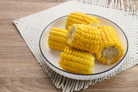 Jagung manis rebus or boiled sweet corn slices served on bowl on wooden background. Space for text.の写真素材