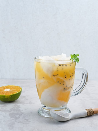 Es Kelapa Jeruk, a typical Indonesian drink made from fresh oranges squeezed with grated young...
