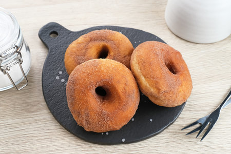 Donat Kentang (Potatoes Donut), donuts with added potato ingredients. Dusted with powdered chocolate and served on a small plate.の写真素材