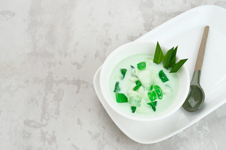 Buko Pandan, a dessert from Philippines, made from jelly, young coconut, evaporated milk, sweetened condensed milk, and ice. Served on glass with cheese topping.の写真素材