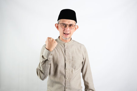 Portrait of Asian Moslem Man with a spirited expression ,celebrating success isolated over white background.の写真素材
