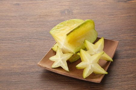 Belimbing or Starfruit (Averrhoa carambola) on wooden plateの写真素材