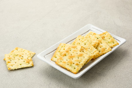 Stacked square biscuits, with a sprinkling of dry vegetables, savory and crunchyの写真素材