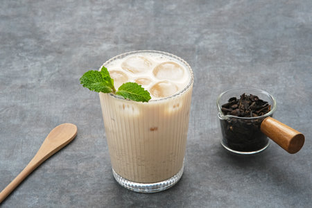 Milk tea with brown sugar syrup in a tall glass with ice and mint leafの写真素材
