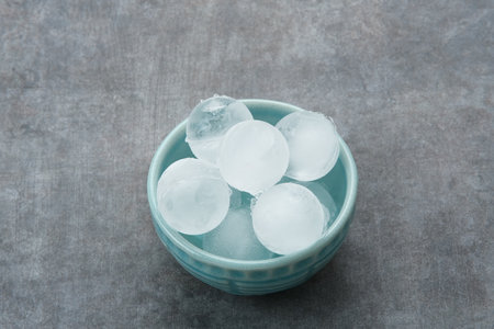 Round ice cubes in small bowlの写真素材