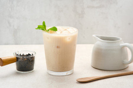 Milk tea with brown sugar syrup in a tall glass with ice and mint leafの写真素材