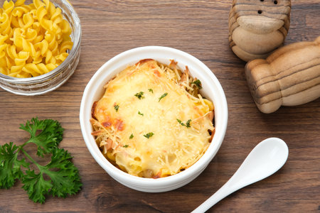 Baked macaroni and cheese on a white bowl with parmesan and herbsの写真素材