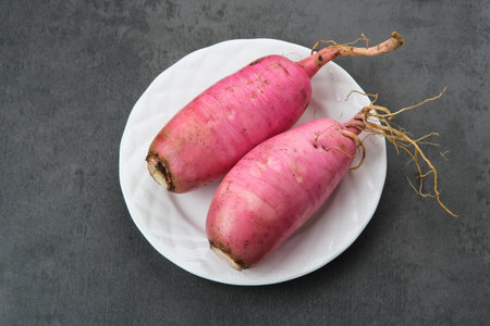 Fresh Red Radish (Lobak Merah) on dark background.