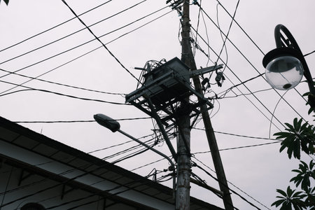 High voltage power pole against blue sky