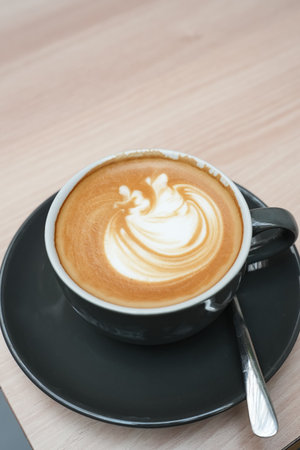 A cup of hot latte coffee on the table for breakfastの写真素材