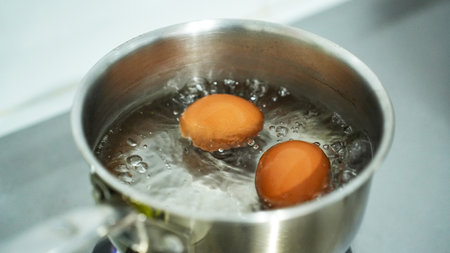 Boiling eggs with saucepan stainless steel for breakfastの写真素材