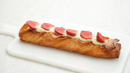 Golden roll pastry with fruit topping and vanilla cream