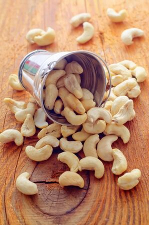 Portion from cashew on the wooden boardの写真素材