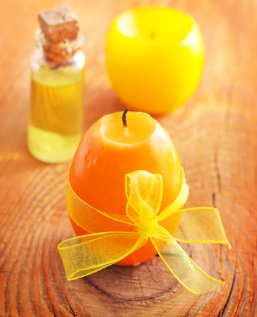Aroma oil in glass bottl and candle on the wooden boardの写真素材