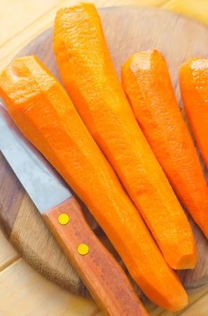 raw carrots and knife on the wooden boardの写真素材