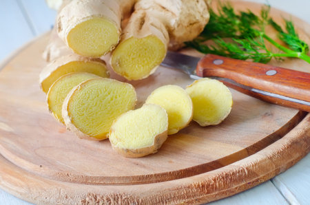 Fresh ginger and knife on the wooden board