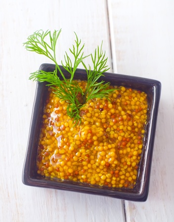 Mustard in the black bowl on tableの写真素材