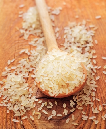 raw rice in the wooden spoonの写真素材