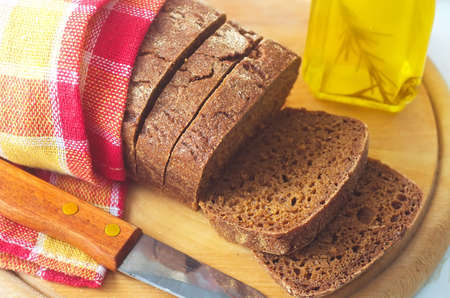 Fresh bread and knife on the wooden boardの写真素材
