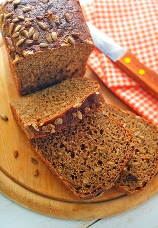 Fresh bread and knife on the wooden boardの写真素材
