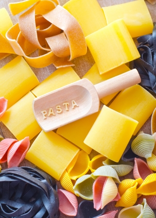assortment of raw pasta and wheat on wooden backgroundの写真素材