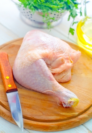 Raw chicken and knife on the wooden boardの写真素材