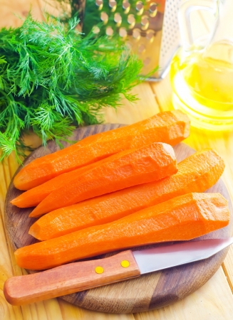 raw carrots and knife on the wooden boardの写真素材