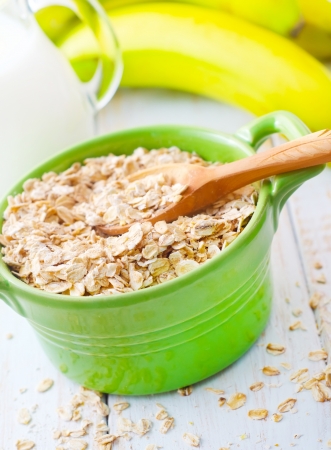 Oat flakes in the green bowl with banana and milkの写真素材