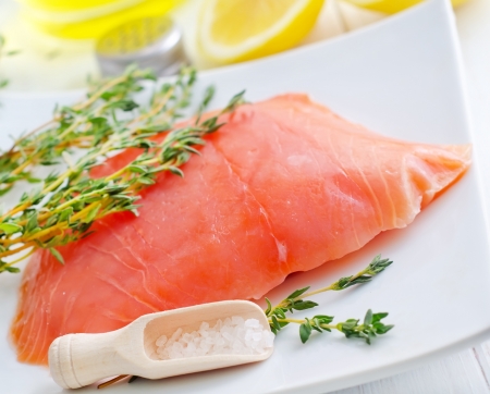 Raw salmon on the white plate with thyme and saltの写真素材