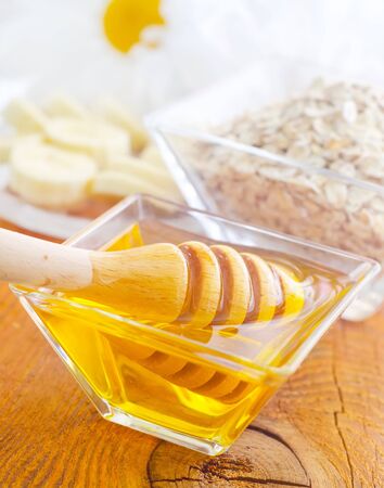 Honey in the glass bowl on the wooden tableの写真素材