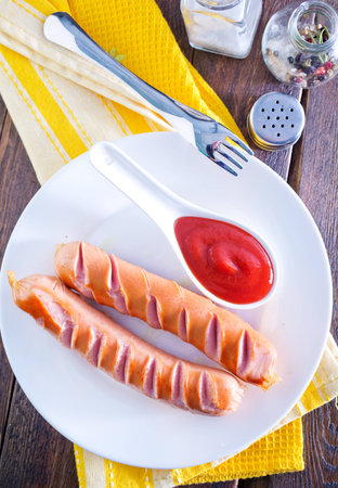 sausages with tomato sauce on white plateの写真素材