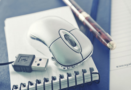 computer mouse and notebooks on a tableの写真素材