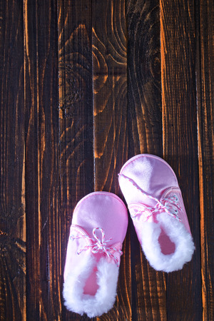 pink baby shoes on the wooden tableの写真素材