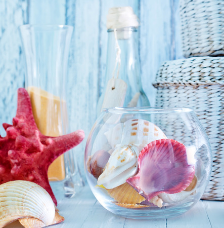 sea shells in glass bowl and on a tableの写真素材