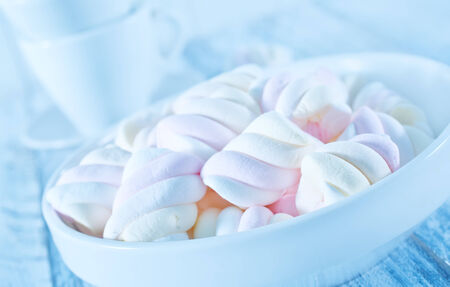 marshmallows in bowl and on a tableの写真素材