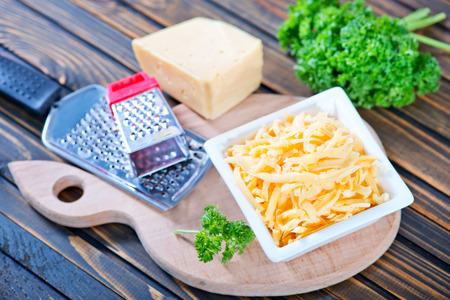 grated cheese in bowl and on a tableの写真素材