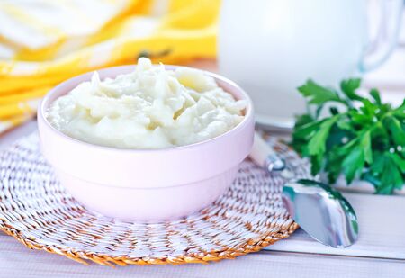 mashed potato in bowl and on a tableの写真素材